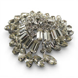 Decorative brooch with clear gemstones on a white background