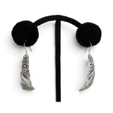 Brocosi.com sterling silver dangle earrings featuring a curved Victorian scroll design on a black display stand.